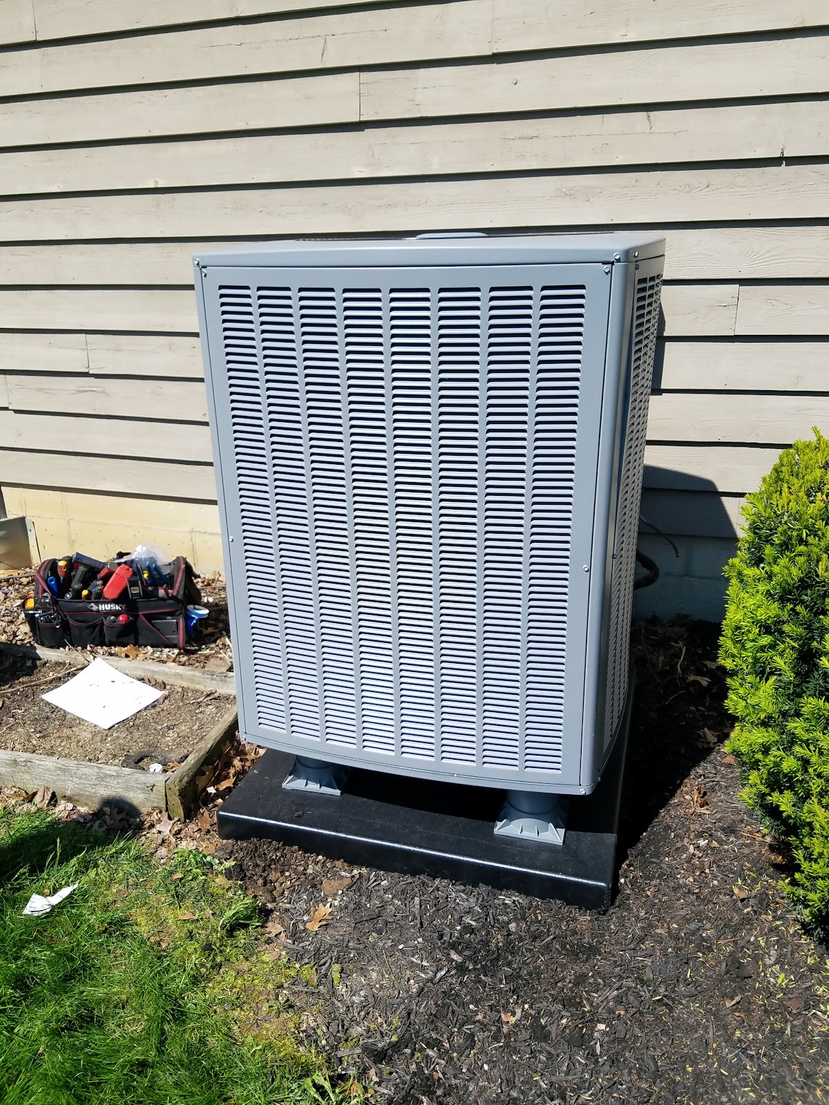 Quality Breeze technician completing an AC condenser installation at a Columbus-area home